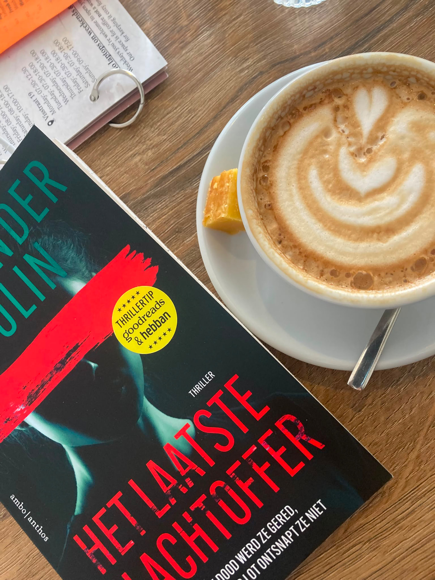 Thriller naast een cappuccino op een cafétafel